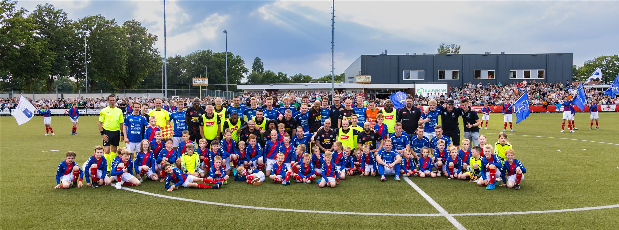 Teamfoto op het veld met volle tribune