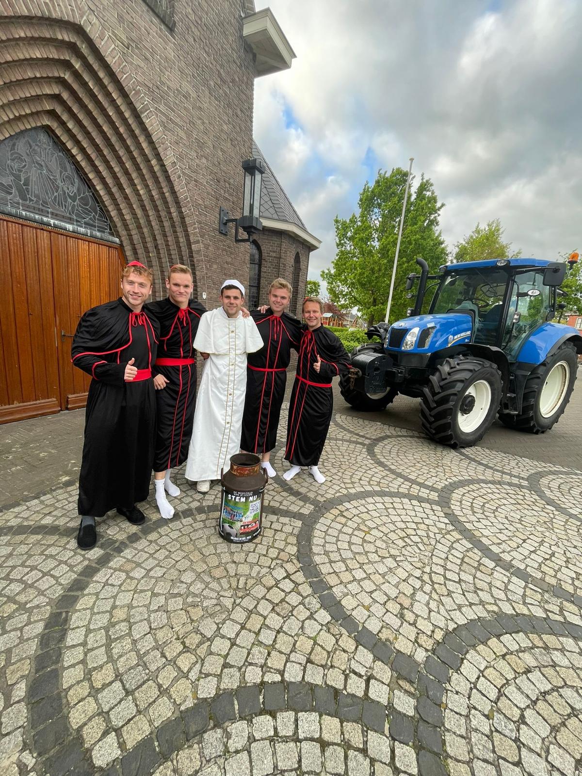 Kardinalen en de paus voor de kerk, met een trekker op de achtergrond